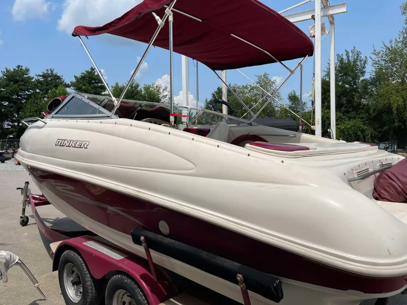 Slide: The Image of 1998 Rinker 212 Captiva Cuddy boat with maroon canopy on trailer. - 13