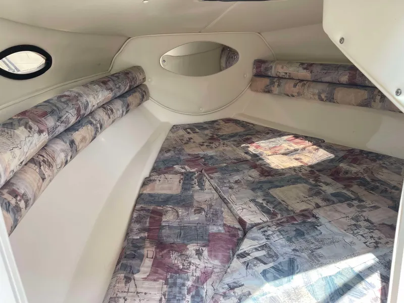 Slide: The Image of Interior of 1998 Rinker 212 Captiva Cuddy with patterned cushions and compact design. - 14