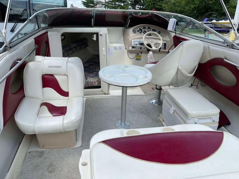 Slide: The Image of 1998 Rinker 212 Captiva Cuddy boat interior with red and white seating and steering console. - 3