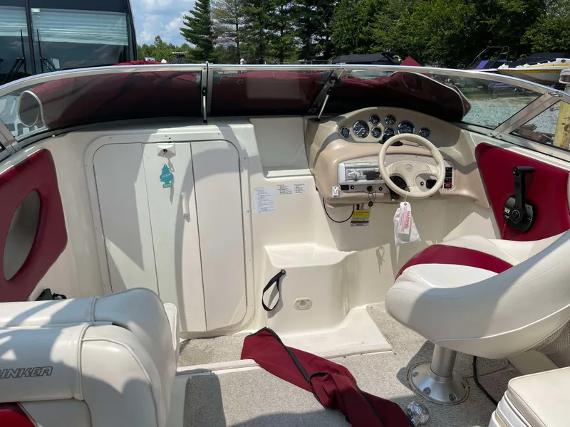 Slide: The Image of 1998 Rinker 212 Captiva Cuddy boat interior with red and white seating, steering wheel, and dashboard. - 4