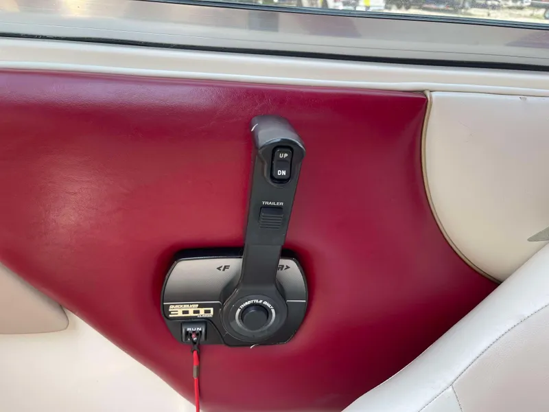 Slide: The Image of 1998 Rinker 212 Captiva Cuddy boat throttle control on red and white interior panel. - 8