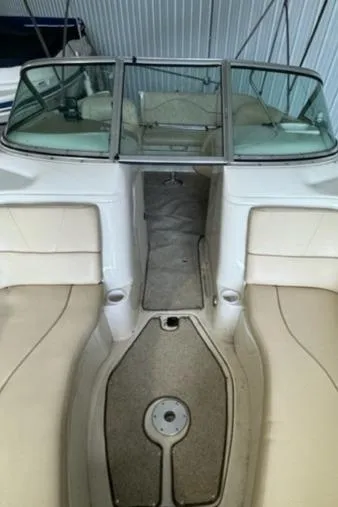 Slide: The Image of 2000 Sea Ray 210 Bow Rider interior with beige seating and carpeted floor. - 10