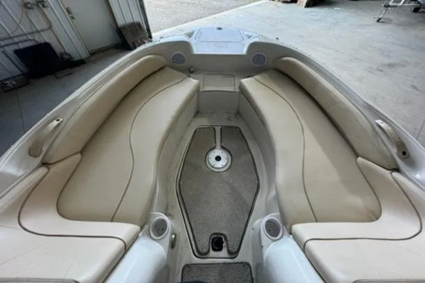 Slide: The Image of 2000 Sea Ray 210 Bow Rider interior with beige seating and carpeted floor. - 14