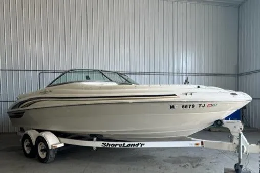 Slide: The Image of 2000 Sea Ray 210 Bow Rider on ShoreLand'r trailer in a garage. - 2