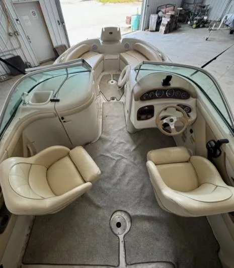 Slide: The Image of 2000 Sea Ray 210 Bow Rider interior with beige seating and dashboard. - 3