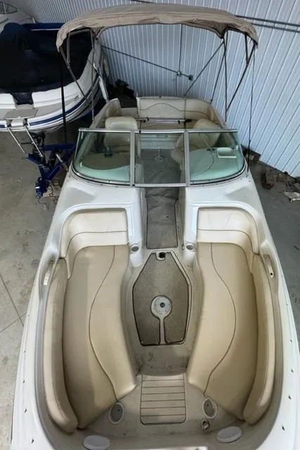 Slide: The Image of 2000 Sea Ray 210 Bow Rider boat with beige interior, stored indoors. - 5