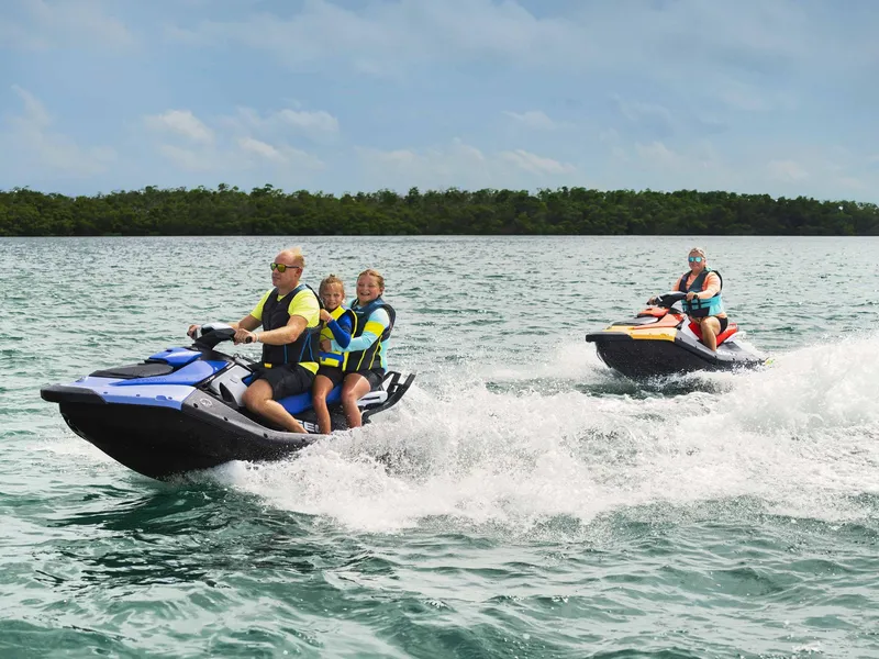 Slide: The Image of 2024 Sea-Doo Spark 3up jet skis on water, family enjoying ride. - 5