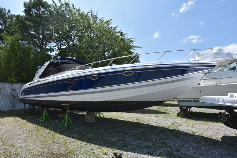 Slide: The Image of 2004 Formula 400 Super Sport boat on stands, blue and white exterior, outdoors. - 1