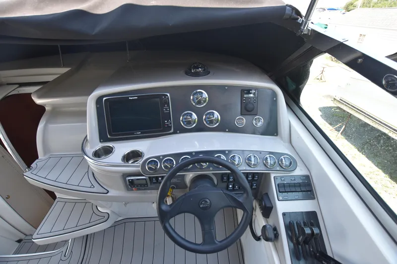 Slide: The Image of 2004 Formula 400 Super Sport boat dashboard with steering wheel and control gauges. - 13