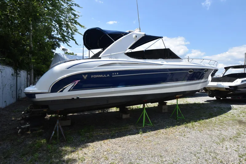 Slide: The Image of 2004 Formula 400 Super Sport boat on stands, blue and white exterior. - 2
