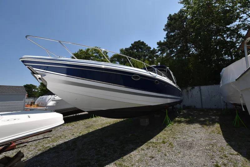 Slide: The Image of 2004 Formula 400 Super Sport boat on land, blue and white hull, parked outdoors. - 3