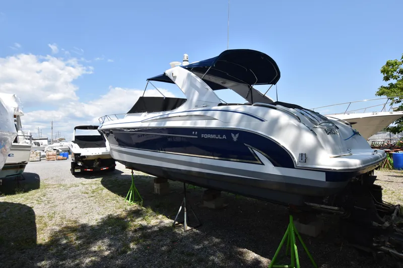 Slide: The Image of 2004 Formula 400 Super Sport boat on stands, blue and white exterior, sunny day. - 4