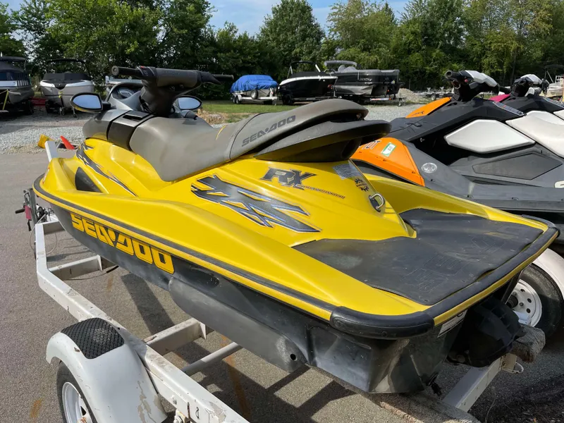 Slide: The Image of 2002 Sea-Doo RX jet ski in yellow on a trailer, parked outdoors. - 5