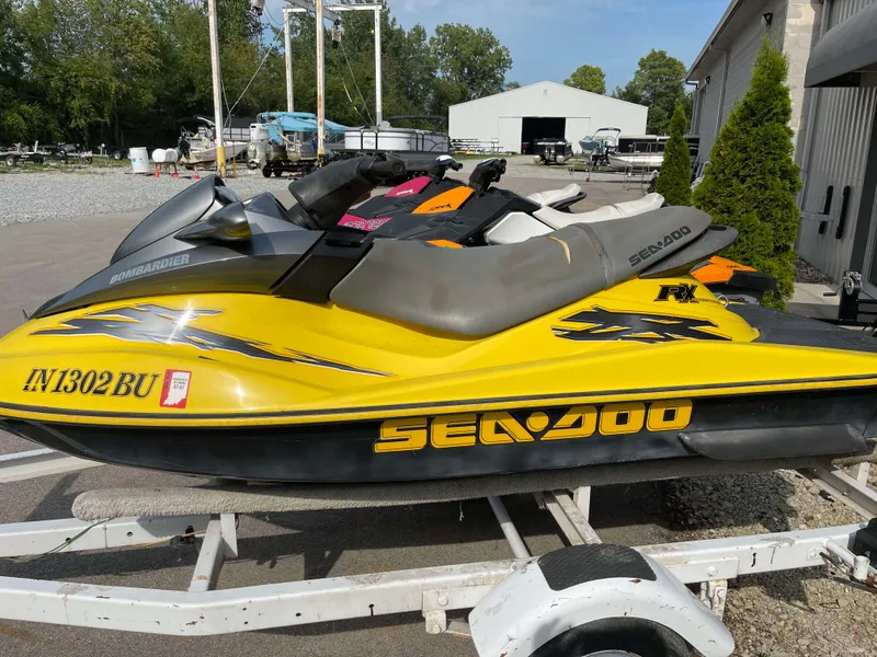 Slide: The Image of 2002 Sea-Doo RX jet ski in yellow on a trailer, parked outdoors. - 6