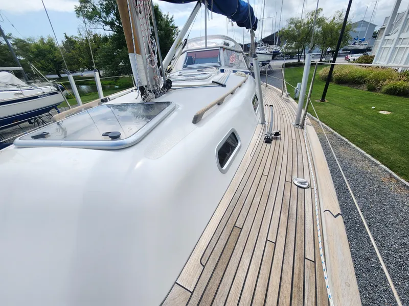 Slide: The Image of 2016 Hallberg-Rassy 342 sailboat with teak deck, docked in a marina. - 12