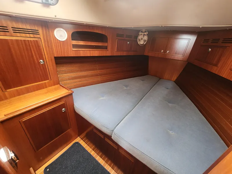 Slide: The Image of Cozy cabin interior of 2016 Hallberg-Rassy 342 sailboat with wooden finish and blue cushions. - 26