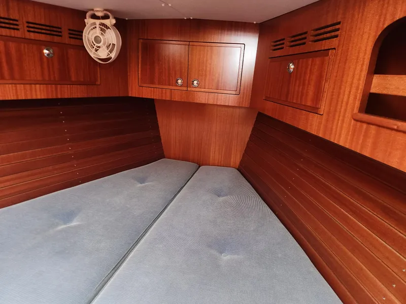 Slide: The Image of Interior cabin of 2016 Hallberg-Rassy 342 yacht with wooden finish and blue cushions. - 28