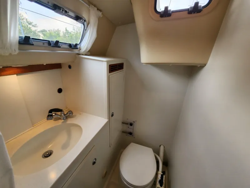Slide: The Image of 2016 Hallberg-Rassy 342 yacht bathroom with sink, toilet, and window. - 38