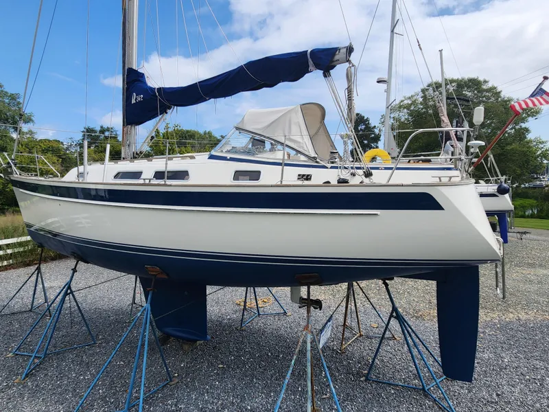Slide: The Image of 2016 Hallberg-Rassy 342 sailboat on stands, blue and white hull, outdoor setting. - 4