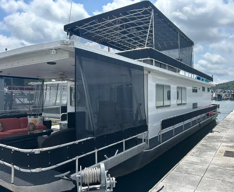 The Image of 1988 Jamestowner houseboat docked, featuring upper deck and shaded seating area. - 0