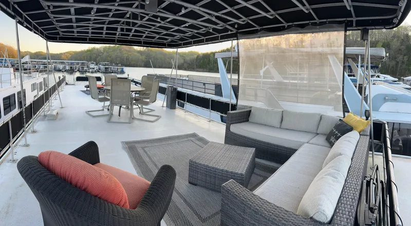 Slide: The Image of 1988 Jamestowner houseboat with spacious deck, outdoor seating, and scenic marina view. - 10