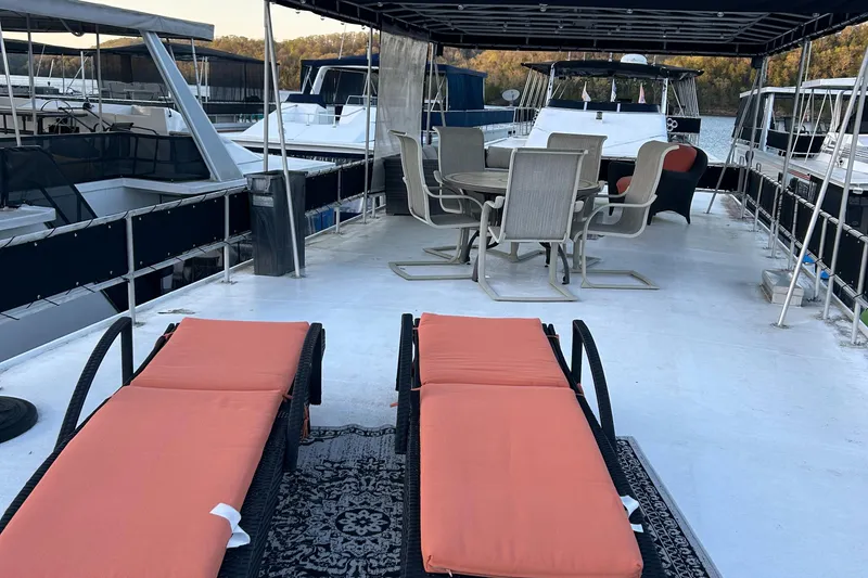 Slide: The Image of 1988 Jamestowner houseboat deck with orange loungers and dining area. - 11