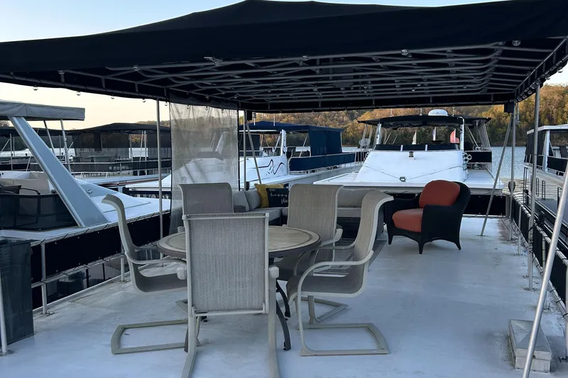 Slide: The Image of 1988 Jamestowner houseboat with outdoor seating and canopy on a calm marina. - 12