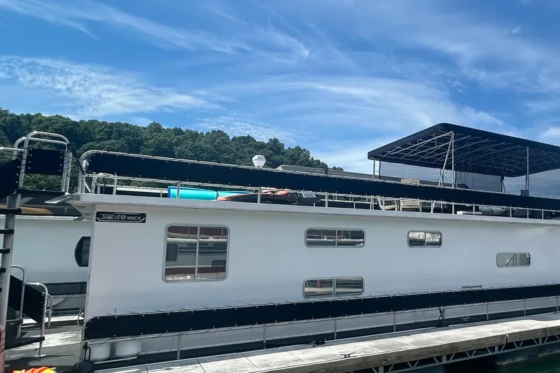 Slide: The Image of 1988 Jamestowner houseboat docked under a clear blue sky. - 13
