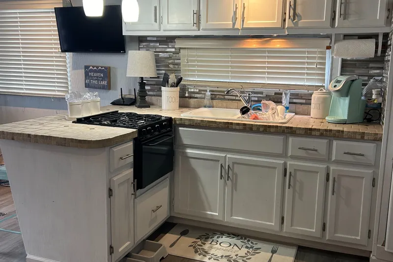 Slide: The Image of 1988 Jamestowner houseboat kitchen with modern appliances and white cabinetry. - 4