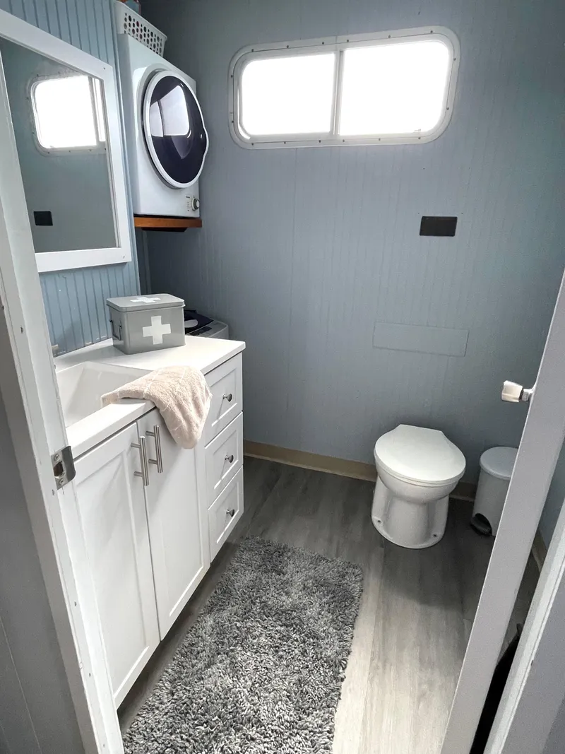 Slide: The Image of 1988 Jamestowner houseboat bathroom with modern fixtures, vanity, and washer-dryer combo. - 6