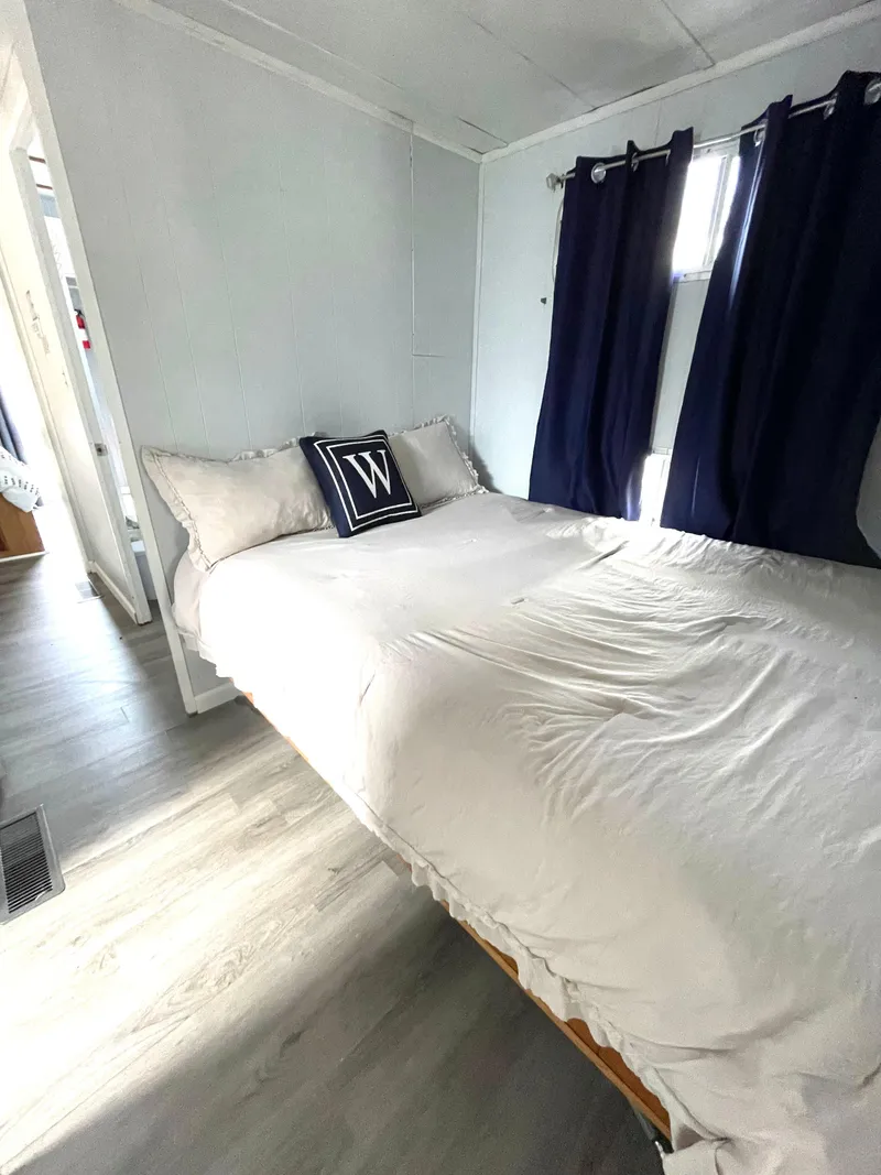 Slide: The Image of Cozy bedroom in 1988 Jamestowner houseboat with white bedding and dark curtains. - 7