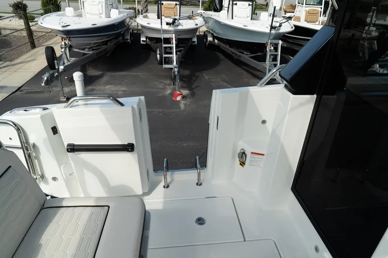 Slide: The Image of 2025 Wellcraft 355 boat interior with seating and access ladder, docked near other boats. - 10