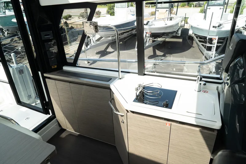 Slide: The Image of Interior of 2025 Wellcraft 355 boat with modern kitchen and large windows. - 17
