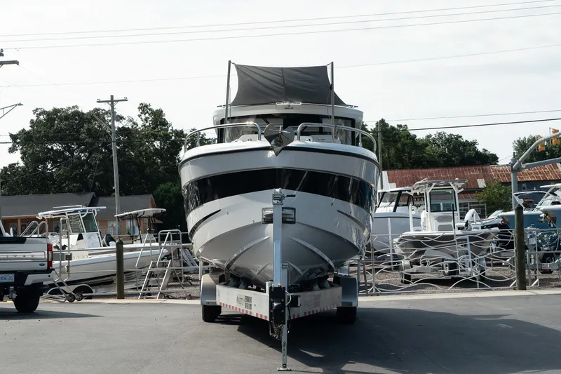Slide: The Image of 2025 Wellcraft 355 boat on trailer, parked in marina lot. - 2