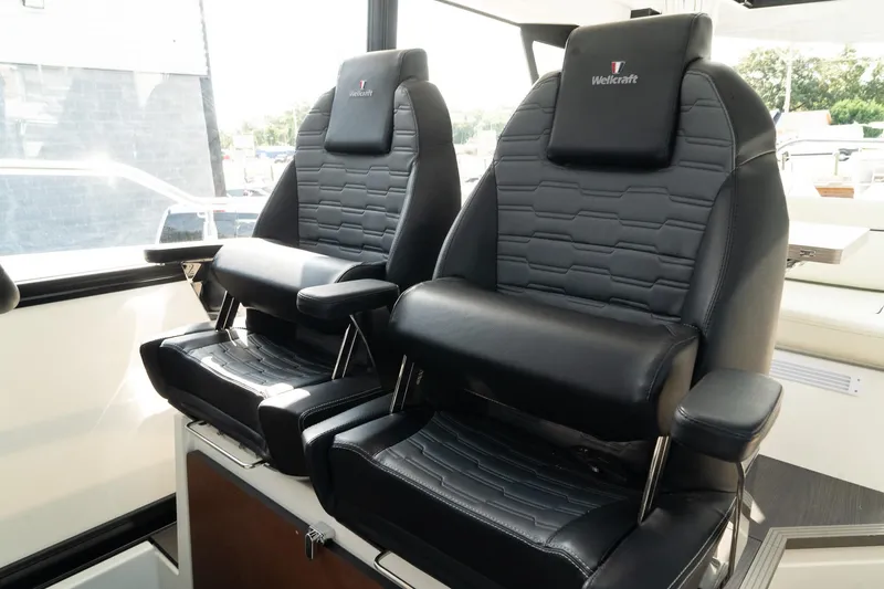 Slide: The Image of 2025 Wellcraft 355 boat interior with two luxurious black captain - 32