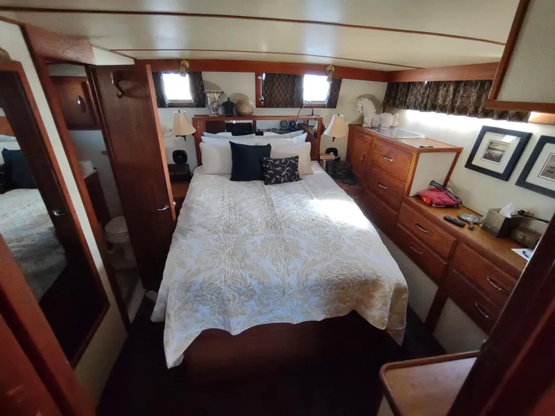 Slide: The Image of 1988 Marinette Marquis Motor Yacht bedroom with cozy bed, wooden cabinets, and nautical decor. - 26