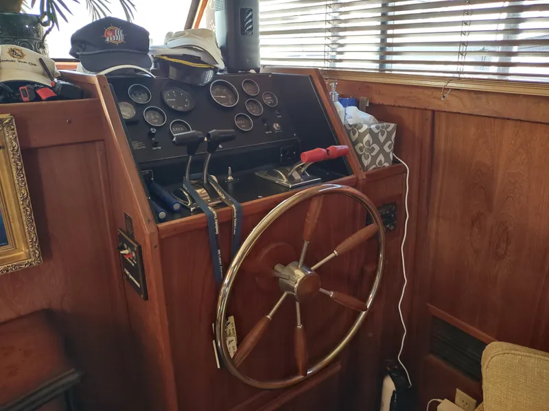 Slide: The Image of 1988 Marinette Marquis Motor Yacht helm with wooden wheel and control panel. - 36