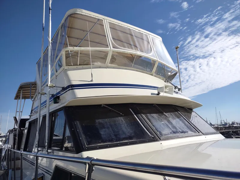 Slide: The Image of 1988 Marinette Marquis Motor Yacht with enclosed upper deck, docked under a clear blue sky. - 4