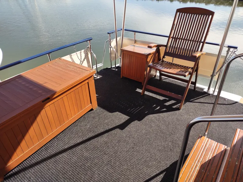 Slide: The Image of 1988 Marinette Marquis Motor Yacht deck with wooden furniture and serene water view. - 5