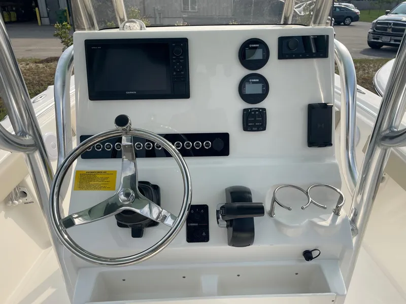 Slide: The Image of 2025 Key West 219 FS boat dashboard with steering wheel and electronic controls. - 2