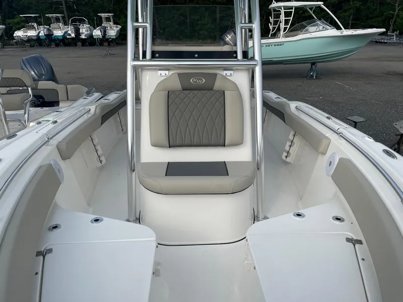 Slide: The Image of 2025 Key West 219 FS boat interior with seating and console, docked outdoors. - 5