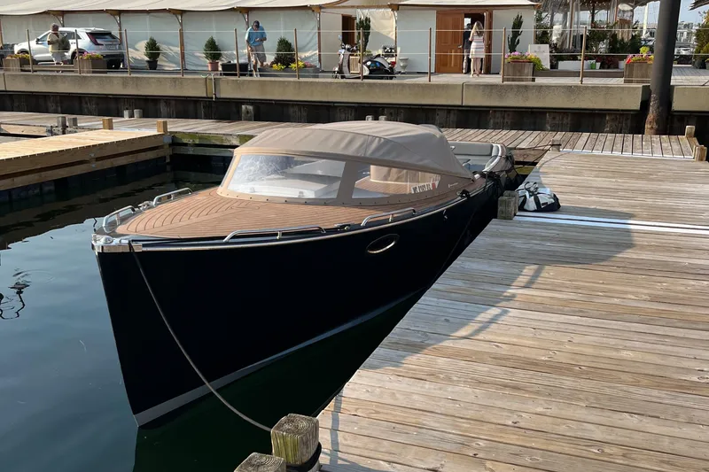 Slide: The Image of 2022 AdmiralsTender C28 boat docked at a wooden pier, featuring a sleek design. - 12