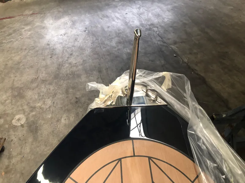 Slide: The Image of 2022 AdmiralsTender C28 boat bow with polished metal cleat and wooden deck detail. - 5