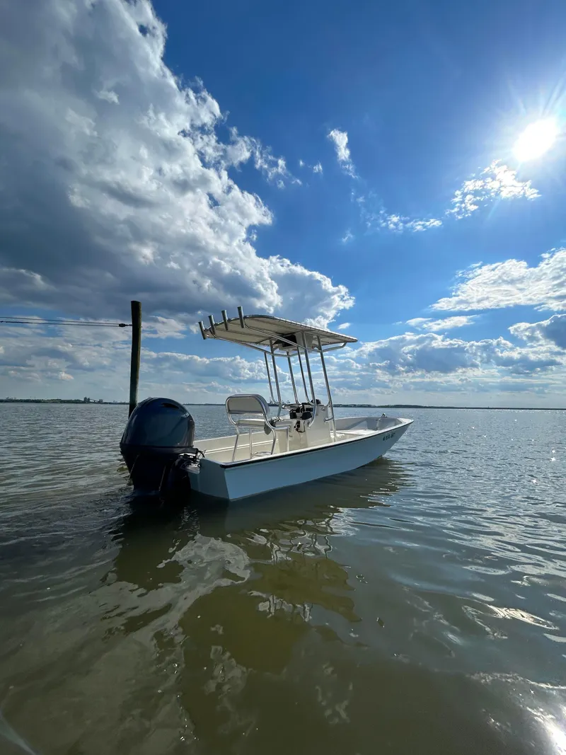 Slide: The Image of 2022 Boston Whaler 17 Montauk boat on calm water under a bright blue sky. - 12