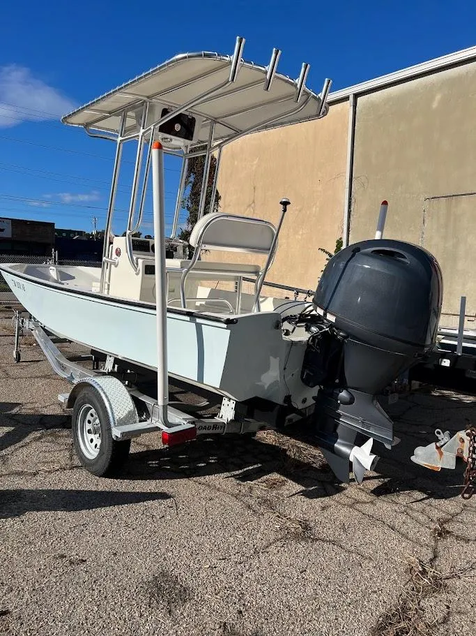 Slide: The Image of 2022 Boston Whaler 17 Montauk boat on trailer, featuring outboard motor and T-top canopy. - 9