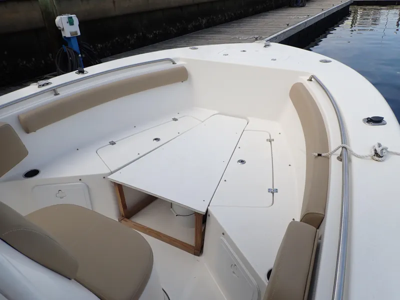 Slide: The Image of 2016 Tidewater 230 CC Adventure boat interior with seating and table near dock. - 19