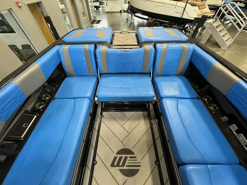 Slide: The Image of 2022 Malibu 25 LSV boat interior with blue and gray seating, spacious layout. - 10