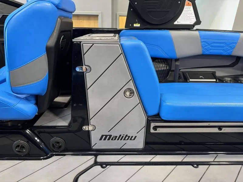 Slide: The Image of 2022 Malibu 25 LSV boat interior with blue and gray seating. - 12
