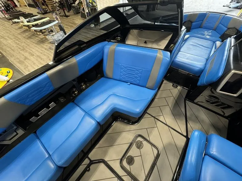 Slide: The Image of 2022 Malibu 25 LSV boat interior with blue and gray seating, modern design. - 13