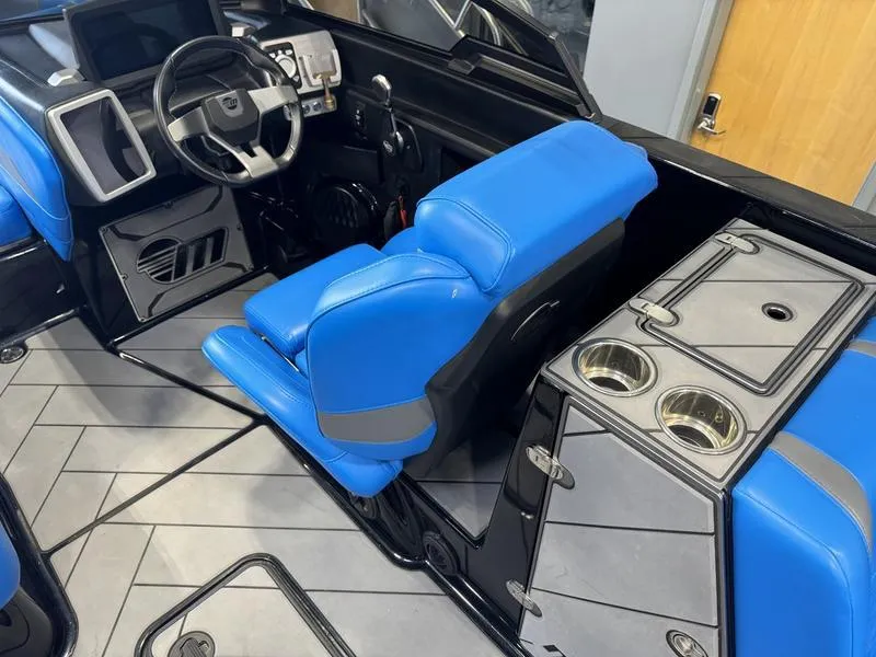 Slide: The Image of 2022 Malibu 25 LSV boat interior with blue seating and modern dashboard. - 14